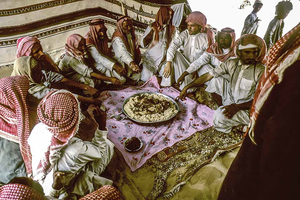 Tor Eigeland - Al-Murrah Bedouins about to dig into the camel meat and rice feast. Saudi Arabia Empty Quarter (Rub al-Khali). W10224