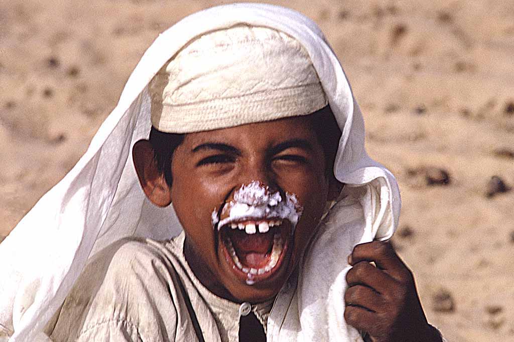 Tor Eigeland - Al-Murrah Bedouin boy after slurping frothy camel's milk from a bowl. W6030