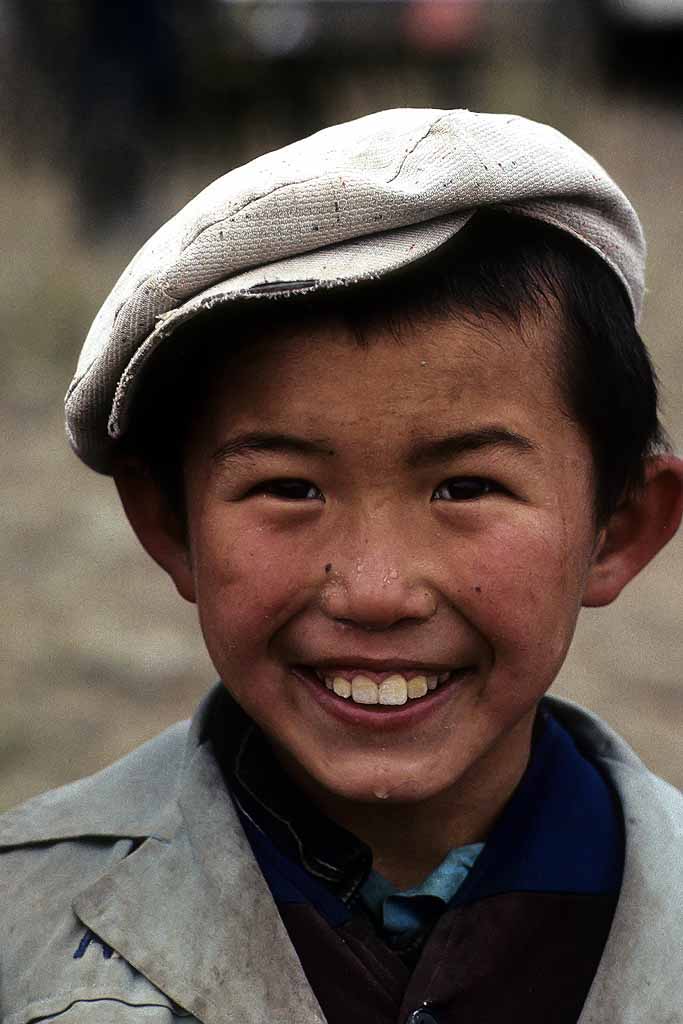 Tor Eigeland - A happy young Kazakh boy with a great smile. He is watching horse racing, a favorite sport in Kazakhstan, Western China. W11245