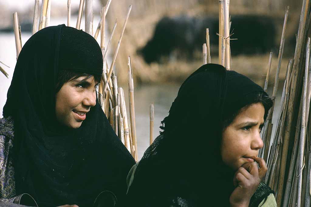 Tor Eigeland - Marsh Arab girls watching their mother weaving. Iraq 1967, prior to the draining of their marshes. W8685