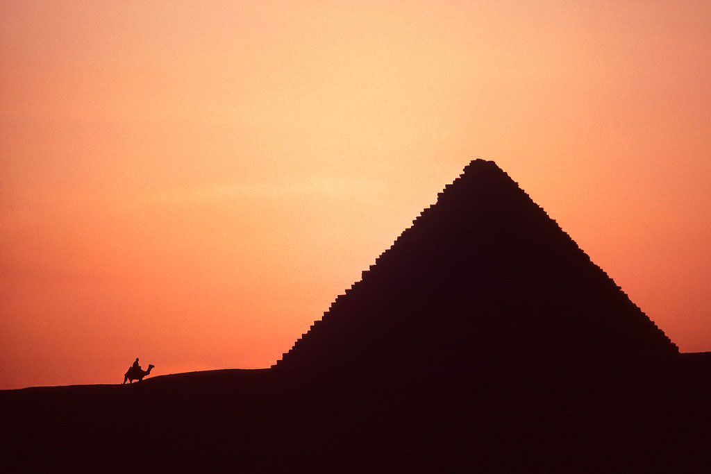 Tor Eigeland - Silhouette of Menkaure Pyramid and camel rider at sunset, Giza. W0381